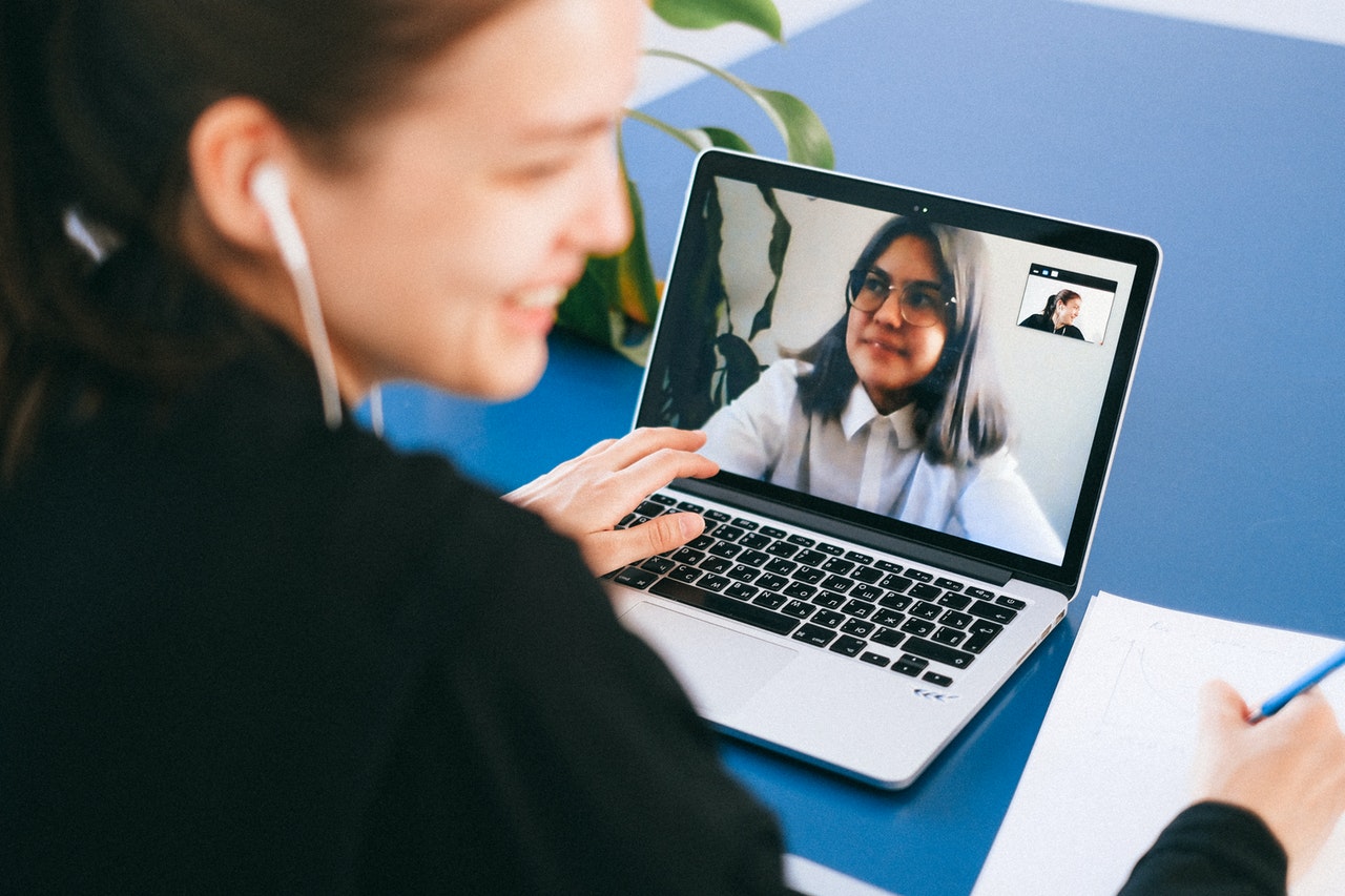 Junge Frau vor einem Laptop mit laufendem Videogespräch