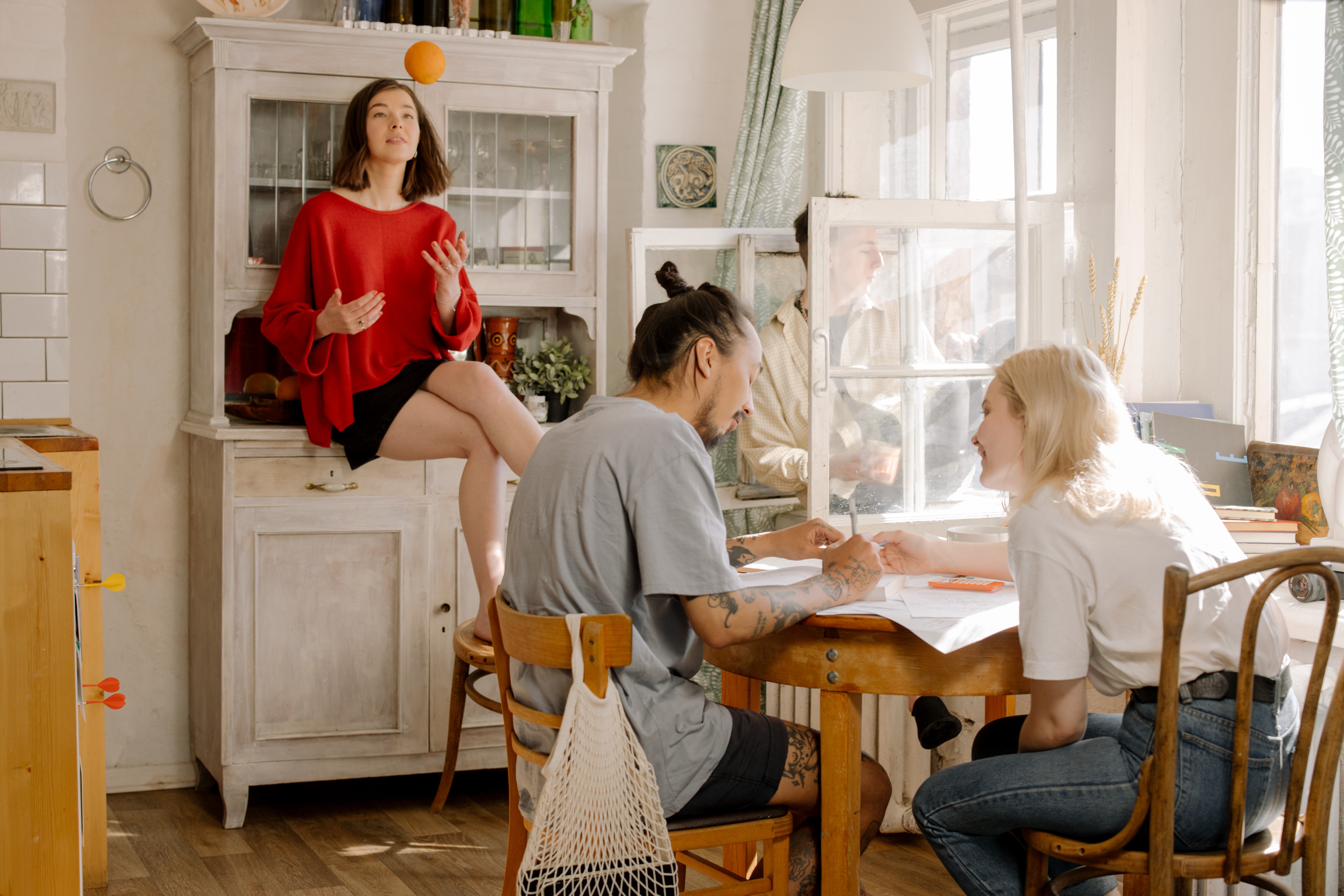 A group of students sit around a kitchen table.